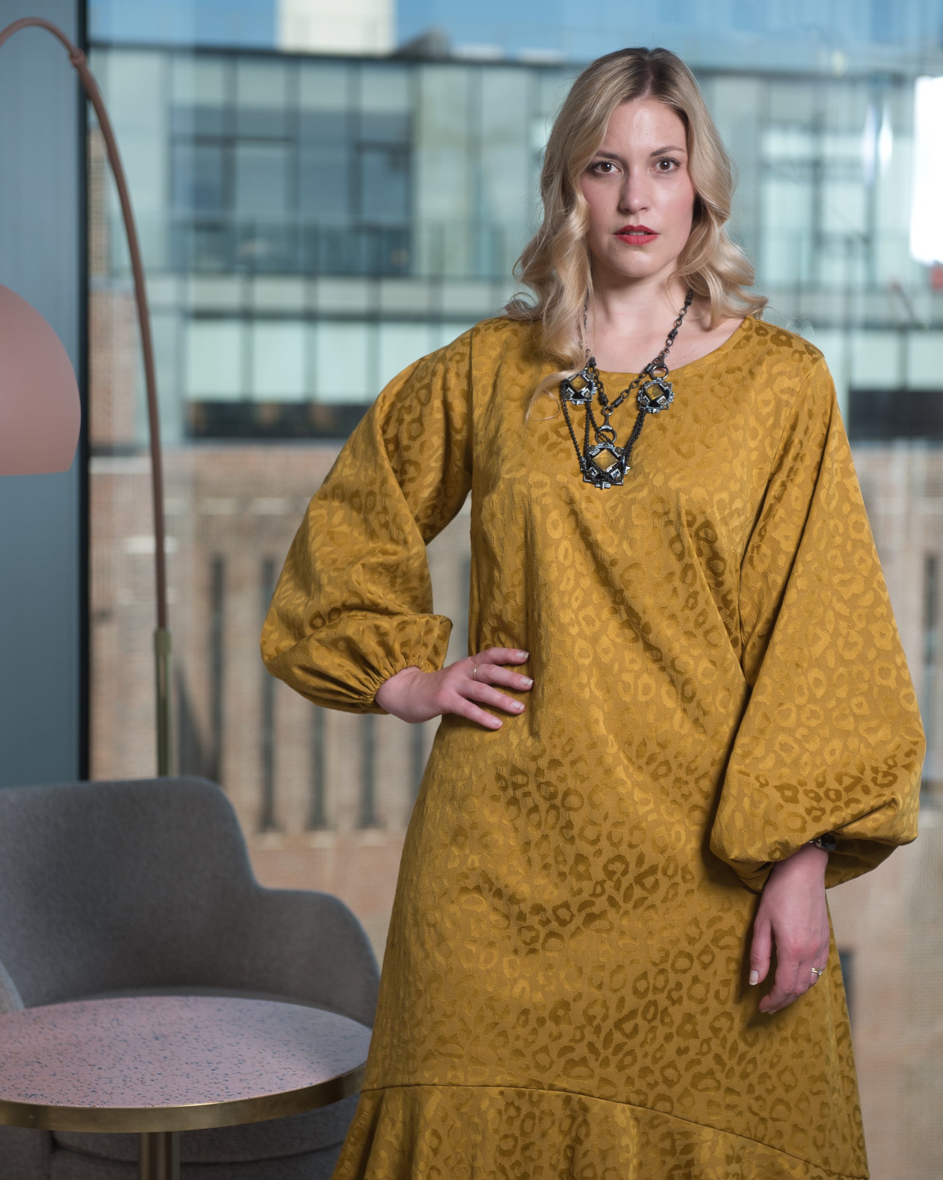 Women's Mid Size Gold Aphrodite Leopard Jacquard Dress shown as a close up, styled with a yellow stone necklace for an elegant look.