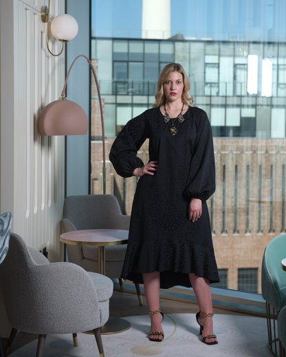 Women's Aphrodite Black Leopard Jacquard Dress styled with a yellow stone necklace and gold chain heels for a chic, coordinated look.