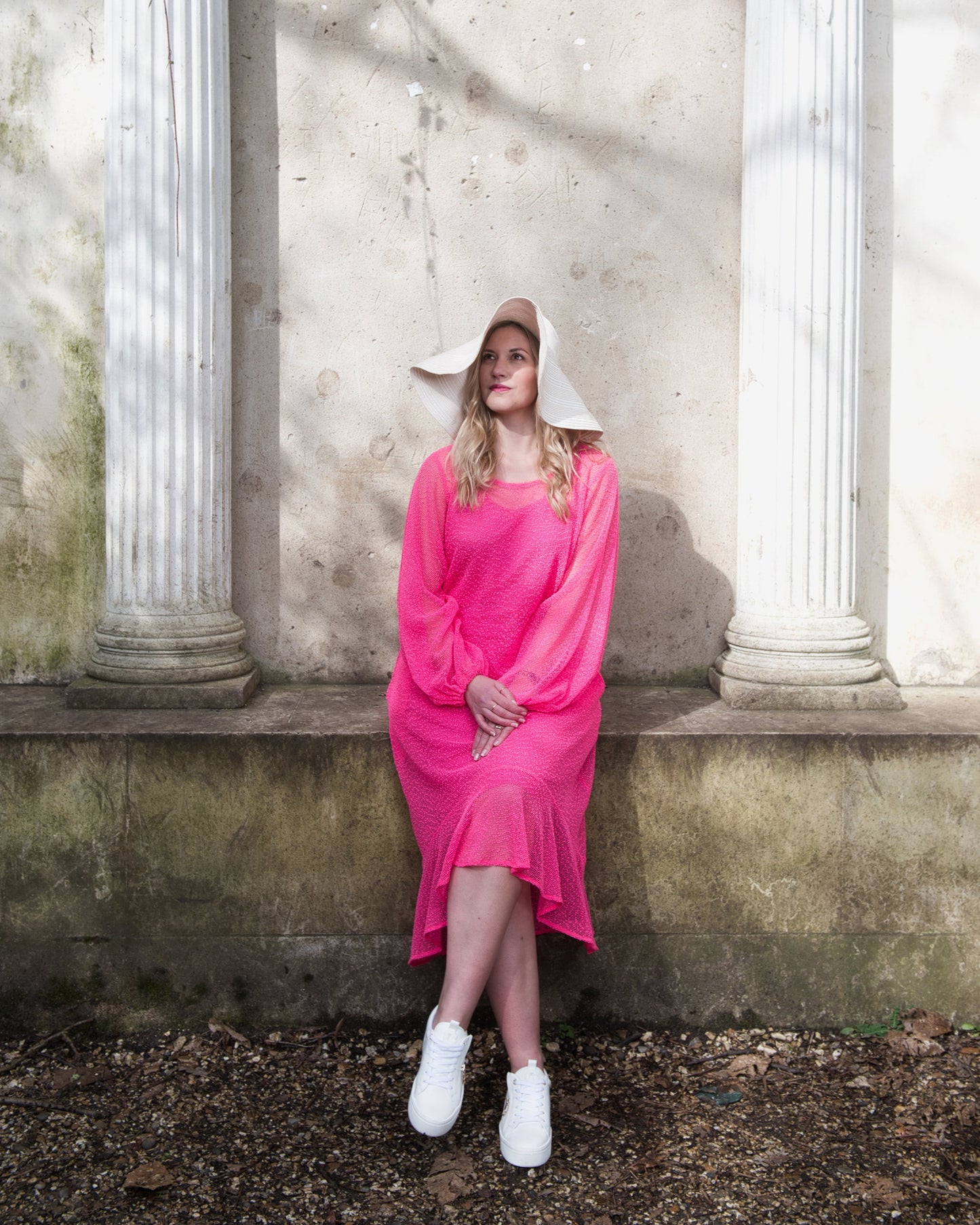 Women's Aphrodite Hot Pink Holiday Resort Dress with a  hot pink undergarment, paired with a white sunhat and white sneakers.