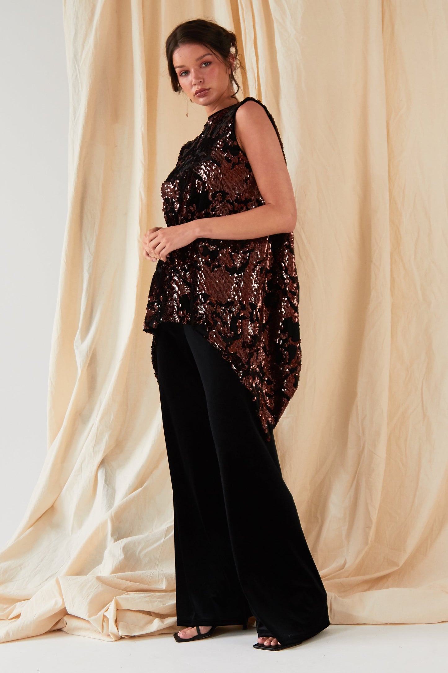 The model is wearing a black sequined top and Sarvin Wide Leg Velvet Trousers.