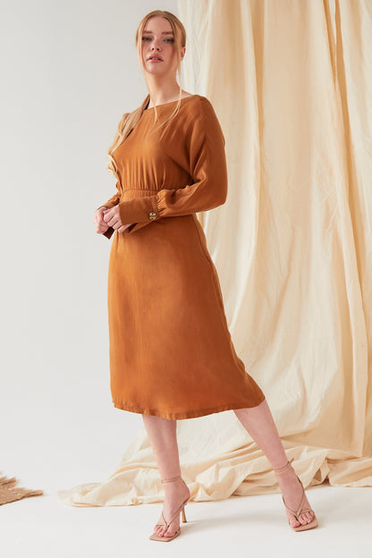 The model is wearing a Sarvin Mustard long sleeve Midi Dress.