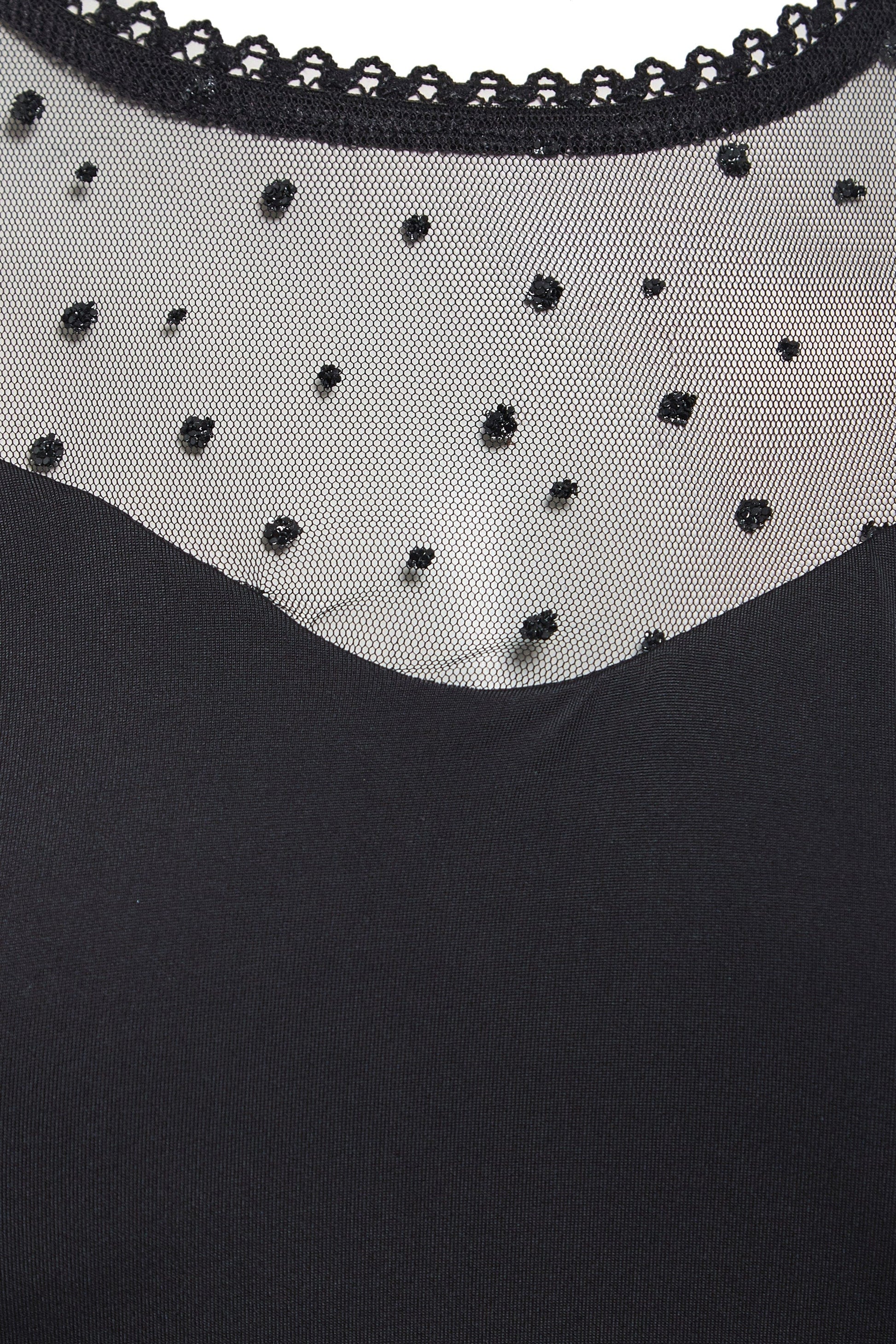 A close up of a Sarvin Long Sleeve Glitter Mesh Bodysuit with beading.