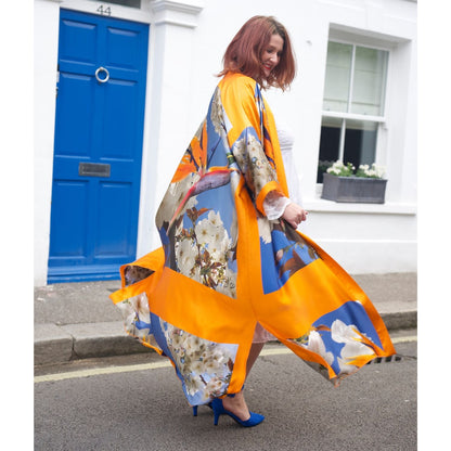 Model twirls in a Bird of Paradise Cherry Blossom Silk Kimono, which gracefully floats in the wind, showcasing its elegant, flowing design.